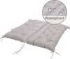 A light gray, tufted cushion with ties, shown on a white background. A circular inset in the upper right corner shows water droplets on a similar fabric with the word 'Waterproof' below. Voir les images du produit