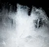 A close-up of ice crystals forming on a surface, with a dark background. Voir les images du produit