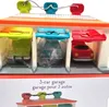 A toy 3-car garage with three cars inside, each in a different colored bay. Voir les images du produit