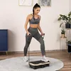 A woman is exercising on a vibration plate in a room. Náhľad obrázku produktu
