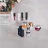 Cosmetics and skincare products displayed on clear acrylic risers, with a bouquet of flowers in the background. Produktbild-Vorschau