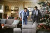 Two men in a living room decorated for Christmas, one holding a can and looking at smoke coming from a chair. Podgląd zdjęcia produktu