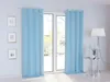 A room with light blue curtains covering a glass door, framed pictures on the wall, and a floor lamp with a side table. Produktbild-Vorschau