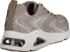 A side view of a beige Skechers sneaker with glitter accents and a transparent sole. Voir les images du produit