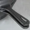 A close-up shot of the handle of a black cast iron pan. Náhled obrázku produktu