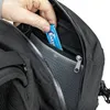 A hand is placing a pack of gum into a zippered pocket of a black backpack. Produktbild-Vorschau