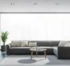 A modern living room with a sectional sofa, coffee table, and a potted plant. Produktbild-Vorschau