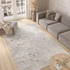 A modern living room with a sofa, ottoman, rug, and coffee table. Anteprima dell’immagine prodotto