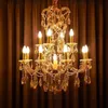 A luxurious crystal chandelier with multiple candle-shaped lights against a brown curtain background. Podgląd zdjęcia produktu