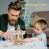 A father and son are building a wooden carousel model together. Anteprima dell’immagine prodotto