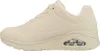 A side view of a beige sneaker. Voir les images du produit