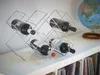 A chrome wine rack holding four bottles of wine on a white shelf, with a globe in the background. Produktbild-Vorschau