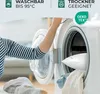 A person is putting a pillow into a washing machine. Produktbild-Vorschau