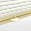 A close-up view of a white pleated blind with a beige operating lever. Produktbild-Vorschau