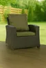 An outdoor chair with cushions on a wooden deck, with a blurred background of greenery and a fence. Produktbild-Vorschau