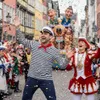 People celebrating at a carnival or parade with confetti falling. Produktbild-Vorschau