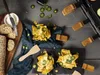 A raclette grill with food items like nachos and bread arranged around it. Produktbild-Vorschau