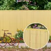 A garden scene with a yellow bamboo fence, a vintage tricycle, and flowers. Produktbild-Vorschau