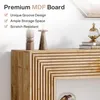 A close-up view of a wooden console table with a ribbed design, featuring decorative items and books on top. Podgląd zdjęcia produktu