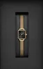 A square-faced gold watch with a black dial and a gold mesh strap, presented in a black box. Produktbild-Vorschau