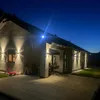 A modern house exterior at dusk, with outdoor lighting illuminating the facade and patio. Náhľad obrázku produktu