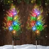 Two solar-powered cypress trees decorated with colorful LED lights stand in the snow, suggesting outdoor Christmas decoration. Anteprima dell’immagine prodotto