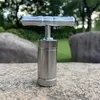 A metal pollen press sits on a rock outdoors. Produktbild-Vorschau