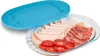 A glass serving dish filled with sliced meats and tomatoes, with a blue lid placed next to it. Náhled obrázku produktu