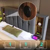 A bed with a headboard featuring storage compartments and charging ports. Produktbild-Vorschau