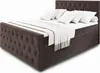 A brown upholstered box spring bed with white bedding and pillows, shown from a diagonal angle against a white background. Produktbild-Vorschau