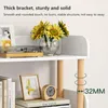 A close-up view of a white shelf unit with wooden legs, decorated with books, a framed picture, a clock, and a vase of sunflowers. Produktbild-Vorschau