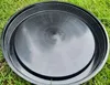 A black plastic lid is placed on green grass. Produktbild-Vorschau