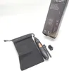 A black precision trimmer with gold accents, a black storage pouch, and a cleaning brush, displayed with its packaging in the background. Podgląd zdjęcia produktu