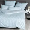 A neatly made bed with striped bedding. Voir les images du produit