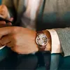 A person wearing a watch and holding a phone. Produktbild-Vorschau