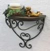 A decorative wall shelf with a candle, ivy, and a cherub figurine. Produktbild-Vorschau