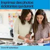 A woman and a girl are looking at photos on a table. Produktbild-Vorschau