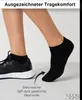 A person's legs and feet wearing black socks and a black athletic shoe. Produktbild-Vorschau
