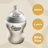 A baby bottle filled with milk, with marketing text and icons on the side. Voir les images du produit