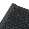 A close-up view of a dark gray ribbed doormat with a black rubber backing. Anteprima dell’immagine prodotto
