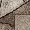 A close-up view of a rug with a wood-like pattern, showing the texture and detail of the material. The corner of the rug is folded back, revealing the underside. Produktbild-Vorschau