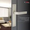 A door handle is shown on a dark door, with a blurred interior scene in the background. Produktbild-Vorschau