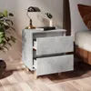 A bedside table with two drawers, a lamp, a book, and a plant, next to a bed. Anteprima dell’immagine prodotto