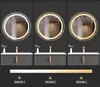 Three illuminated round mirrors are displayed above bathroom vanities, showcasing different light temperatures. Produktbild-Vorschau