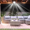 An outdoor patio area at night, illuminated by a bright LED floodlight. Produktbild-Vorschau