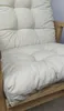 A close-up view of a beige cushion on a wooden chair. Produktbild-Vorschau