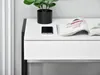 A close-up view of a white desk with a black frame, featuring a potted plant, a smartphone, and an open magazine. Anteprima dell’immagine prodotto