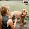 A woman is grooming a dog outdoors with an electric trimmer. Produktbild-Vorschau