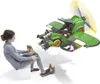 A young girl is playing with a Nintendo Labo Toy-Con vehicle set, controlling a green vehicle with a propeller. Produktbild-Vorschau