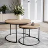 Two round coffee tables of different sizes are placed on a rug in a living room setting. A vase with flowers is on the larger table, and a mug is on the smaller table. Voir les images du produit